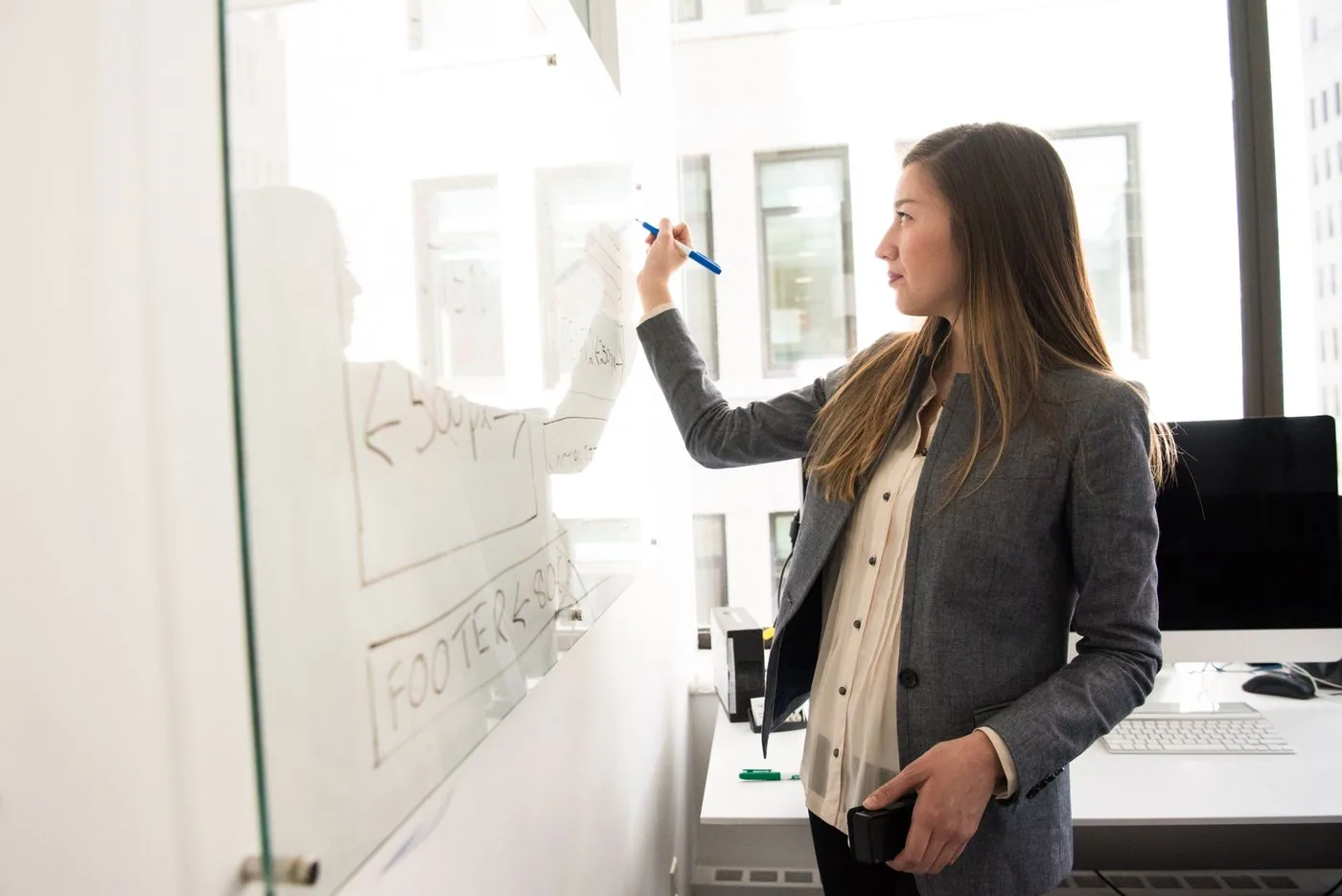 A colleague explaining a workflow on an office whiteboard