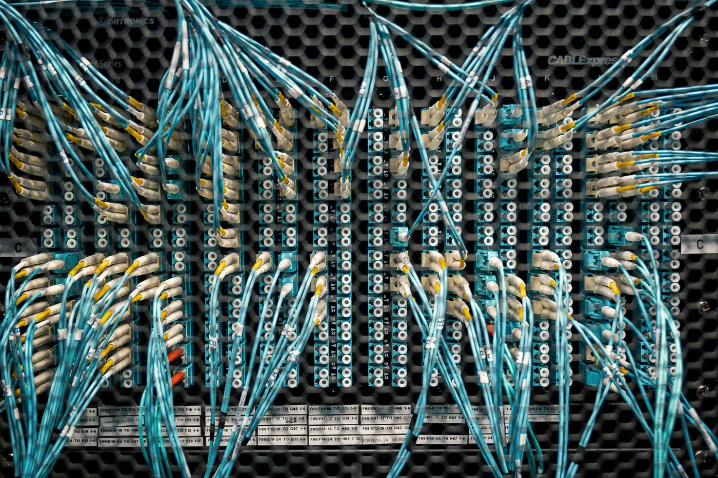 Color-coded fiber optic cables arranged across network equipment
