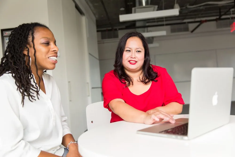 Two professionals exchanging ideas with a laptop between them