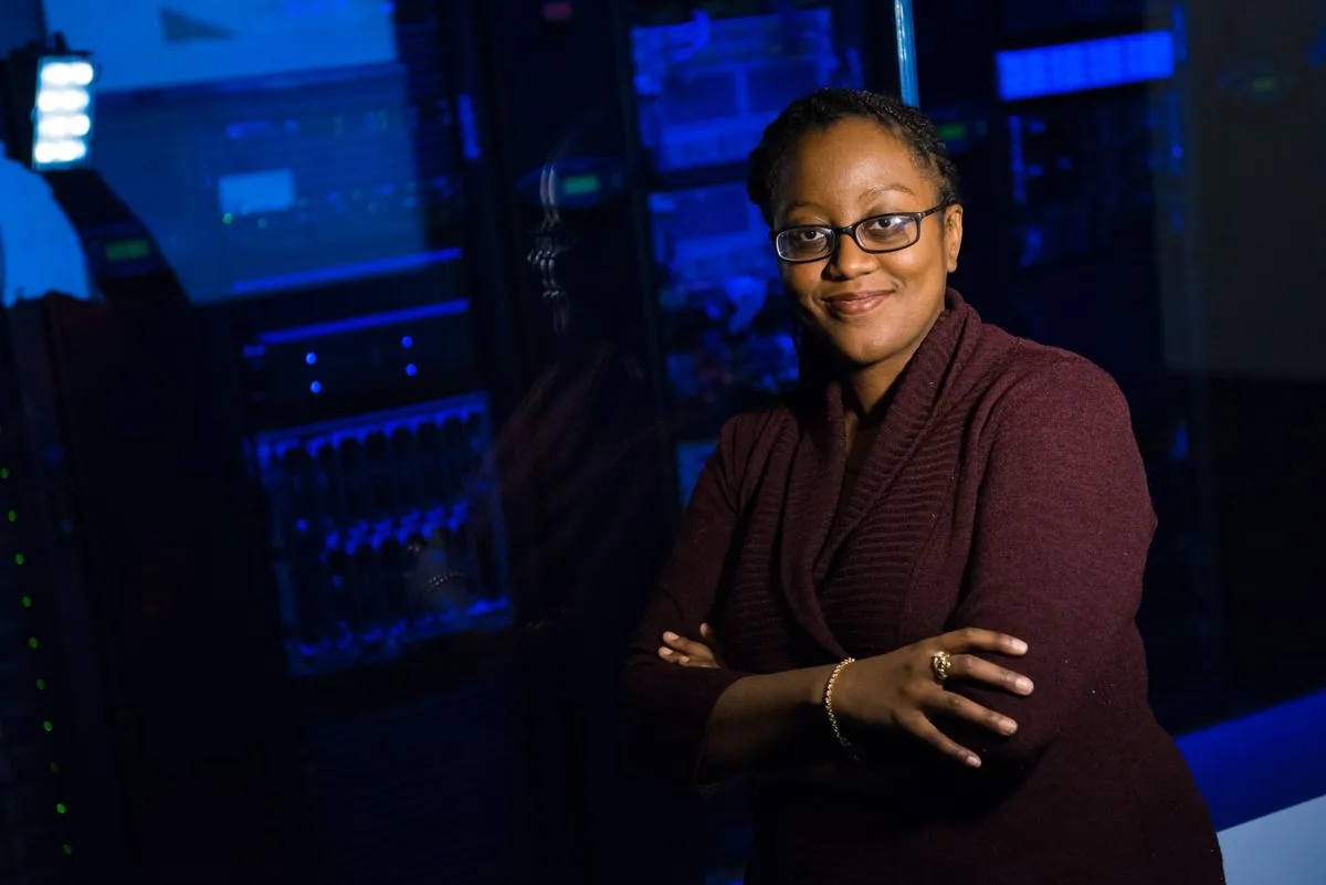A technology professional standing beside illuminated server racks